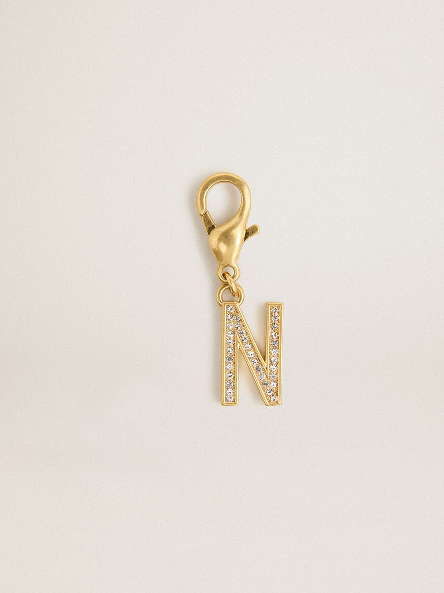 bedeltje met de letter n in goudkleurig messing met kristallen.
