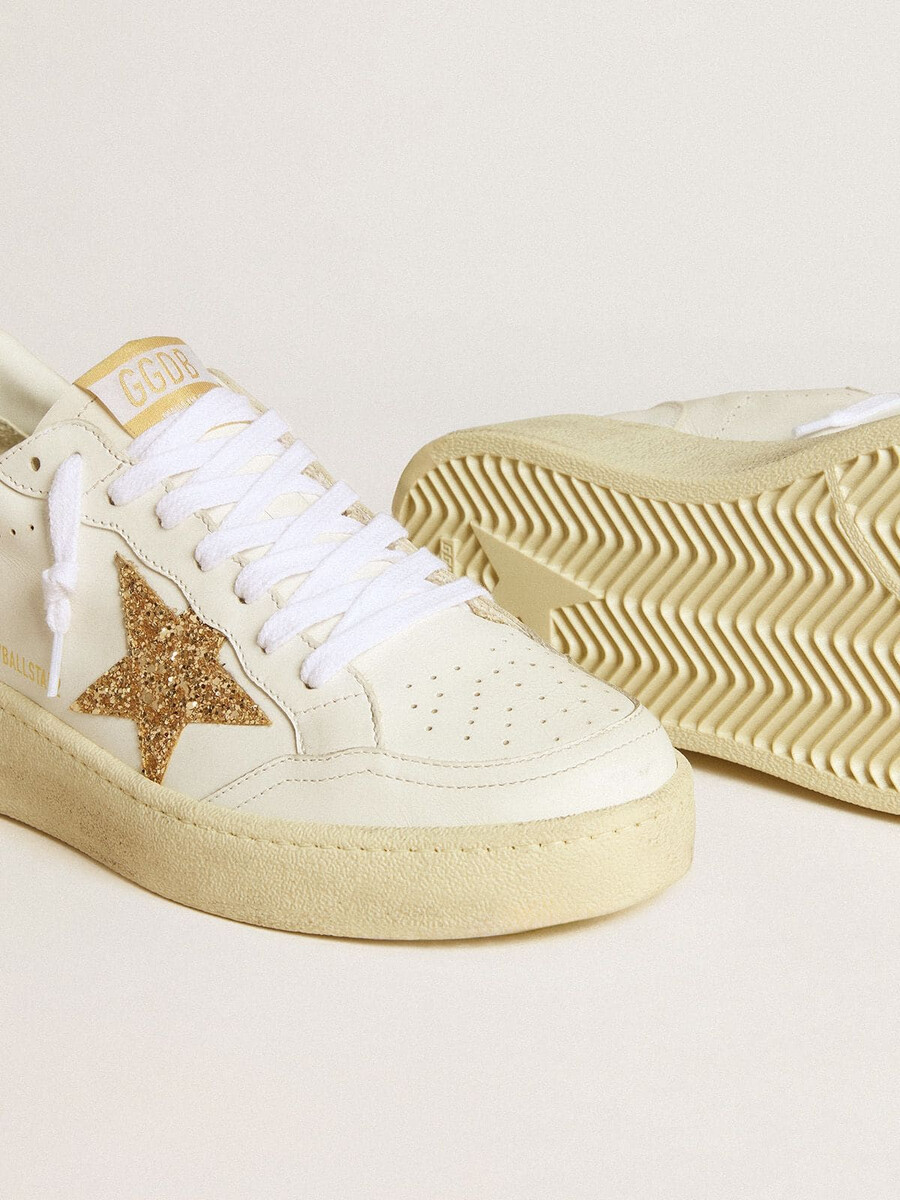 dames ball star in wit leer met gouden glitterster en zwarte glitterhiel.