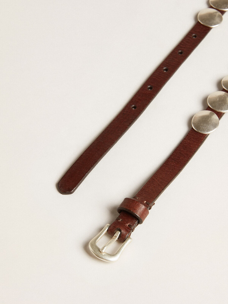 dunne trinidad-riem van donkerbruin leer met zilveren studs.