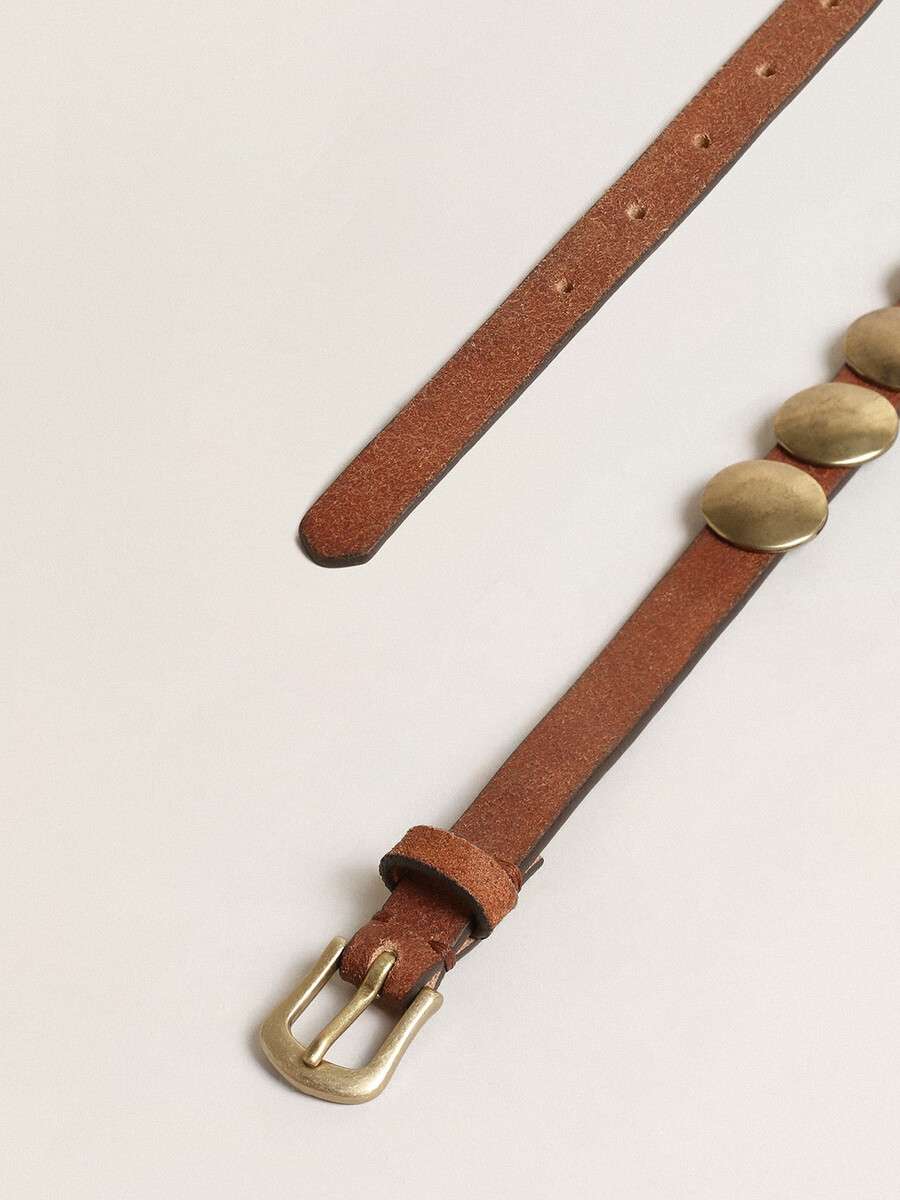 trinidad-riem van verouderd lichtbruin leer met grote gouden studs.