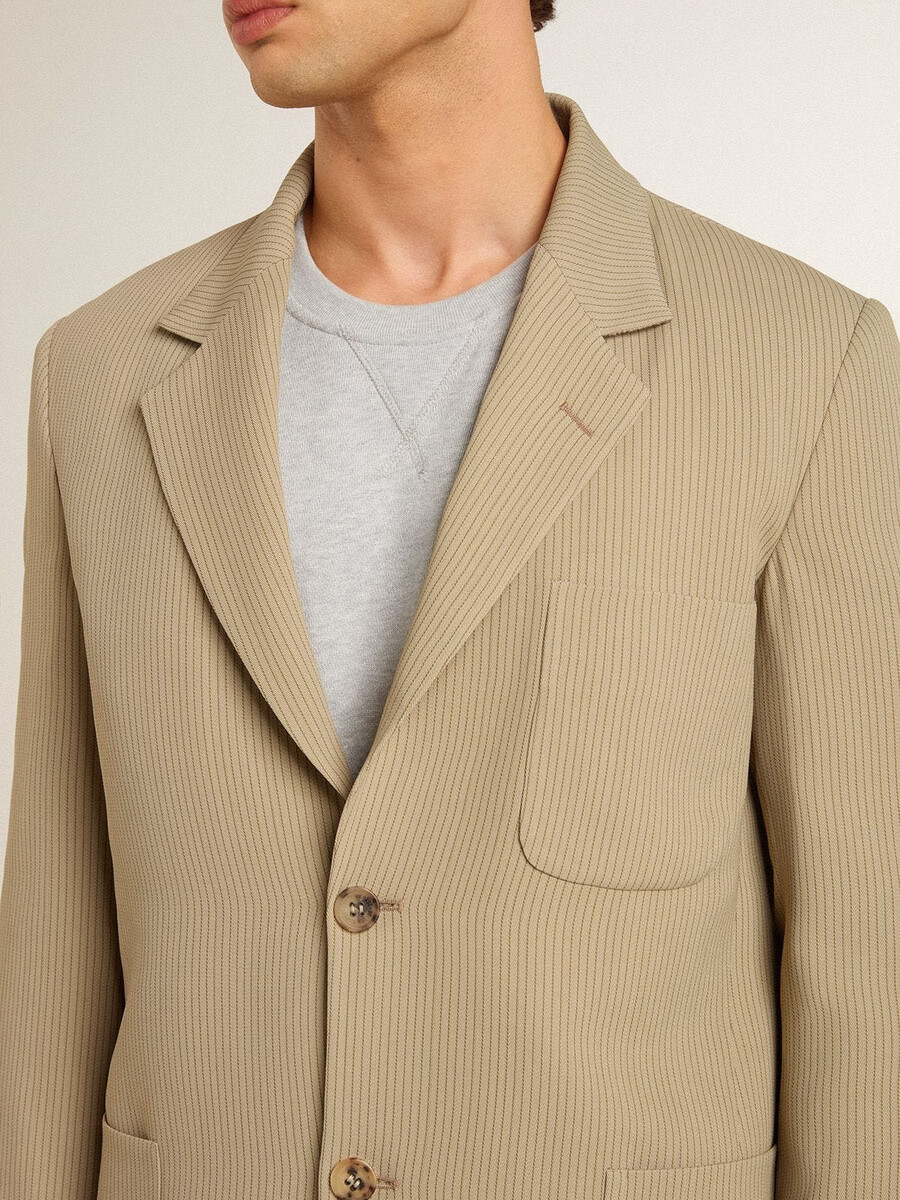 beige herenjas met krijtstreep enkele rij knopen en een oversized pasvorm.