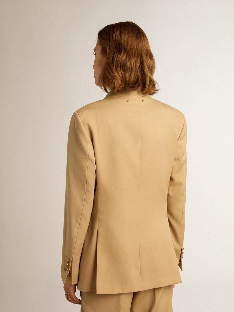 damesblazer met dubbele rij knopen in zandkleur met gouden knopen in heraldisch motief.
