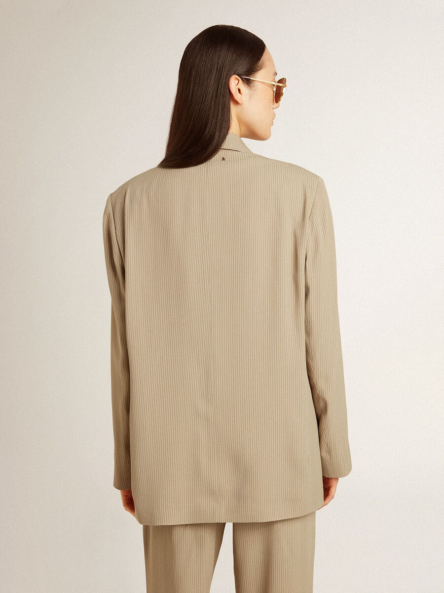 beige damesjasje met krijtstreepjes en enkele rij knopen met een oversized pasvorm.