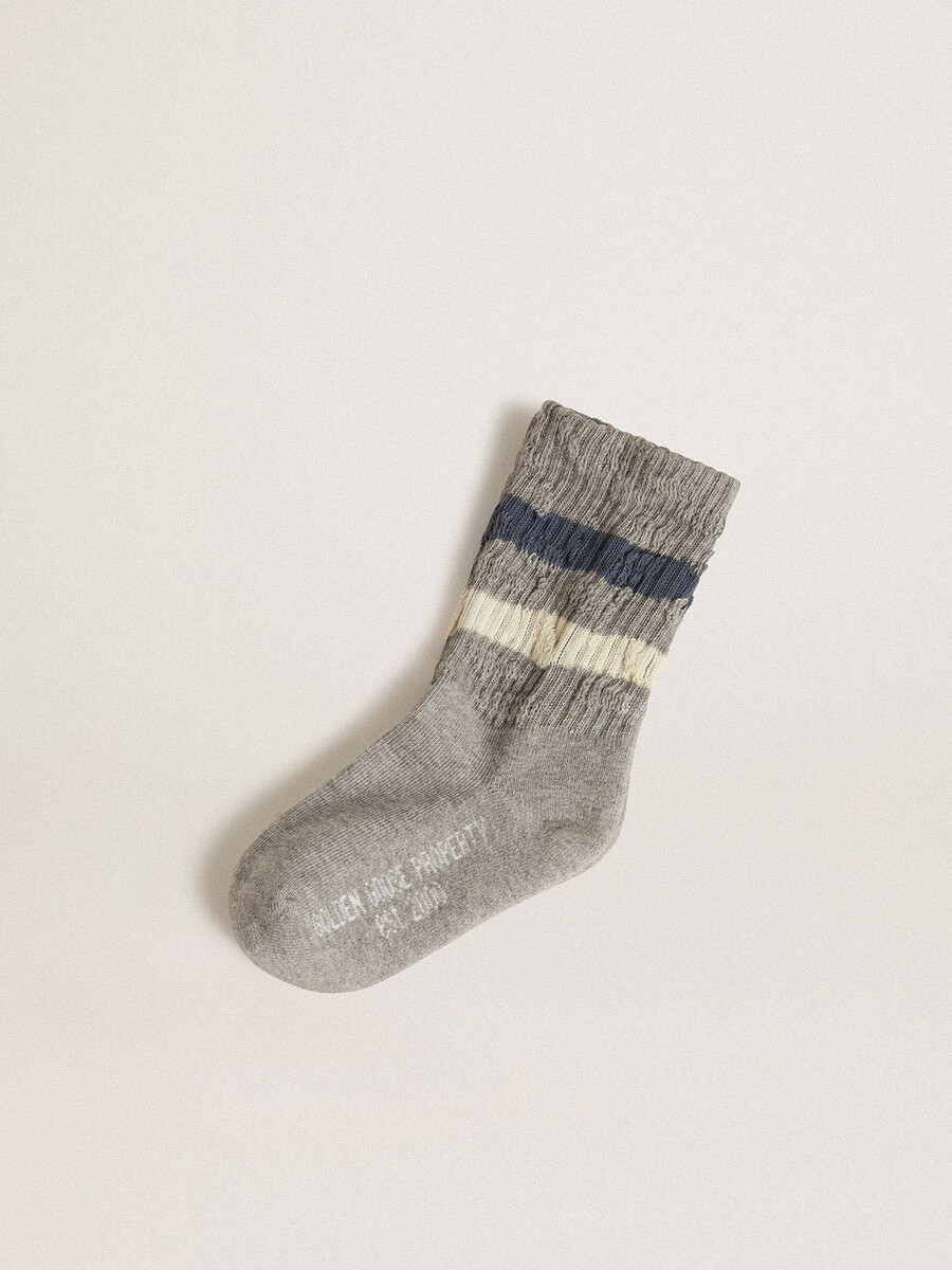 grijze kindersokken met een verweerde look en witte en blauwe strepen.