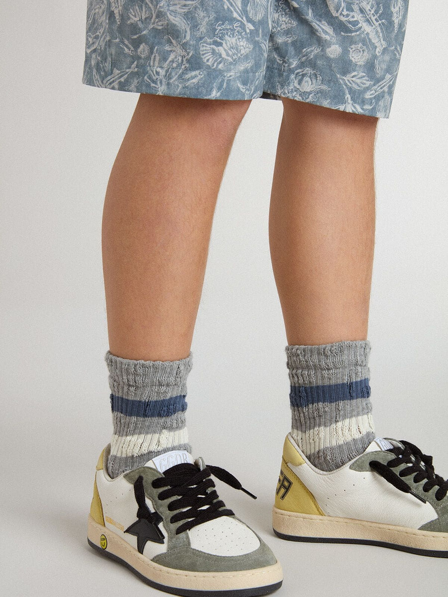 grijze kindersokken met een verweerde look en witte en blauwe strepen.