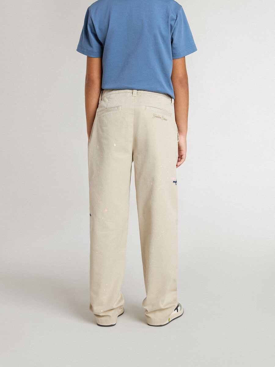 beige chino broek voor kinderen met veelkleurige spetters.