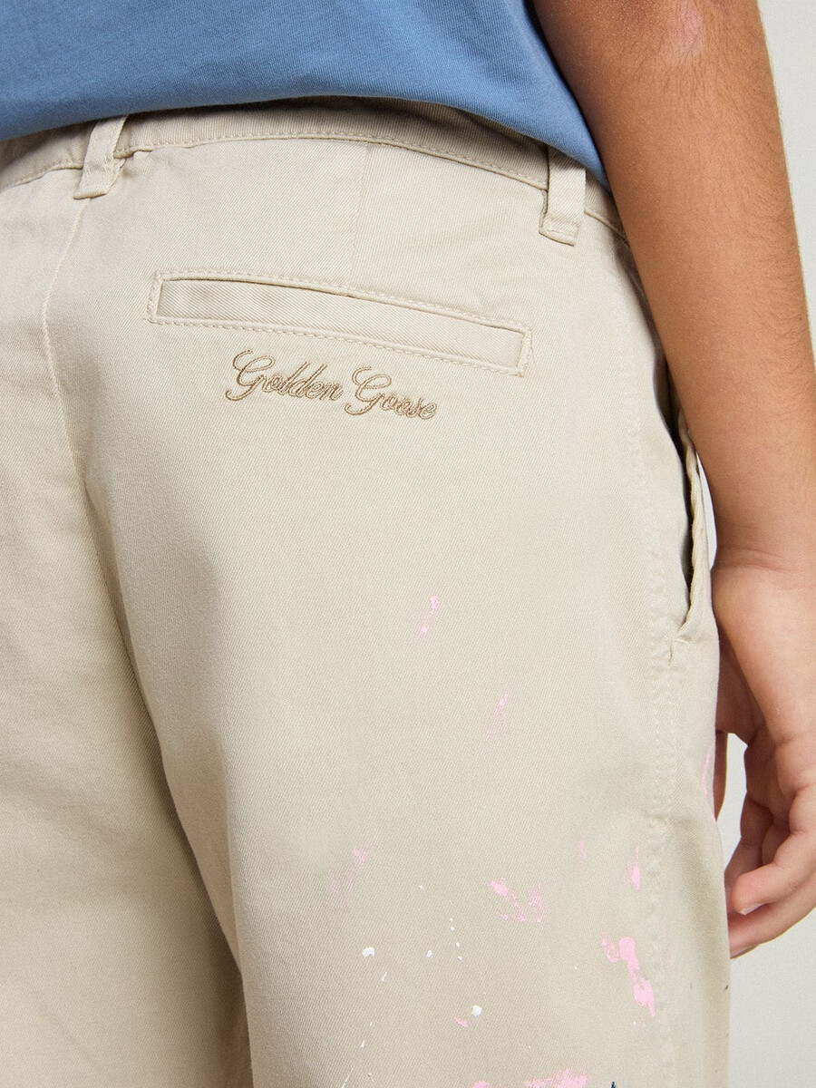 beige chino broek voor kinderen met veelkleurige spetters.