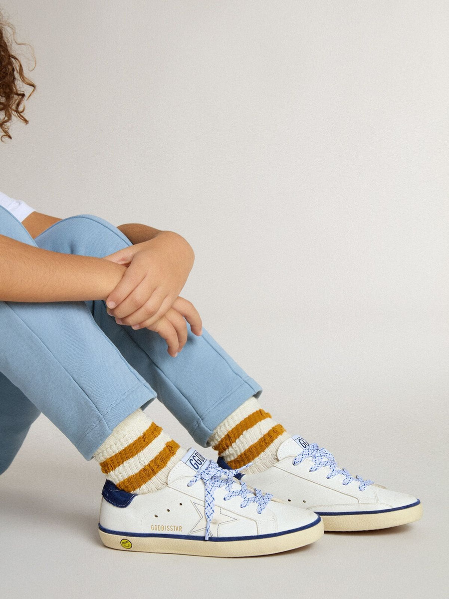 junior super-star in wit leer met een hielstuk van blauw suède.