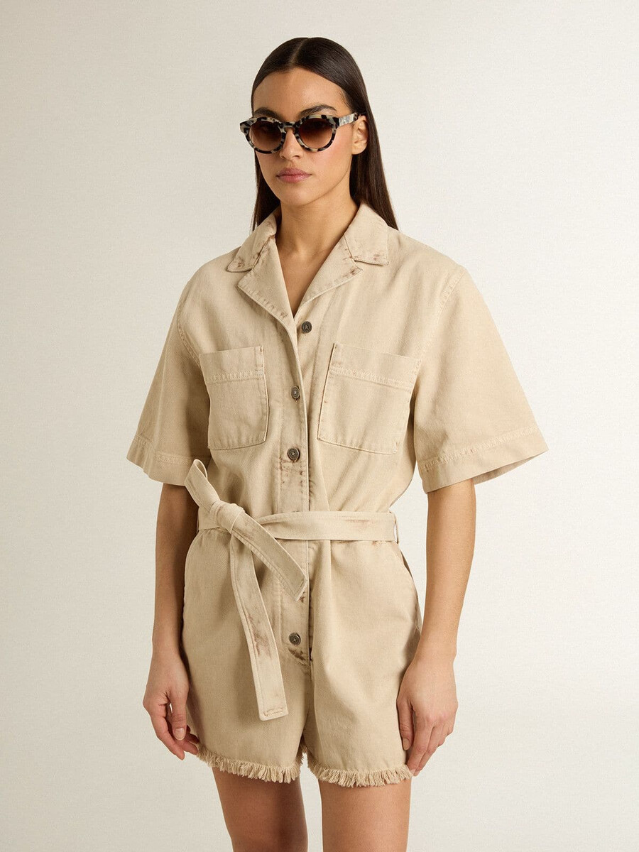 damesjumpsuit van beige denim met riem en gerafelde zoom.