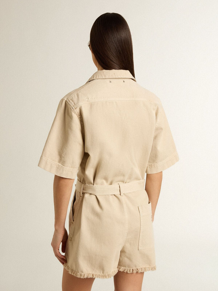 damesjumpsuit van beige denim met riem en gerafelde zoom.