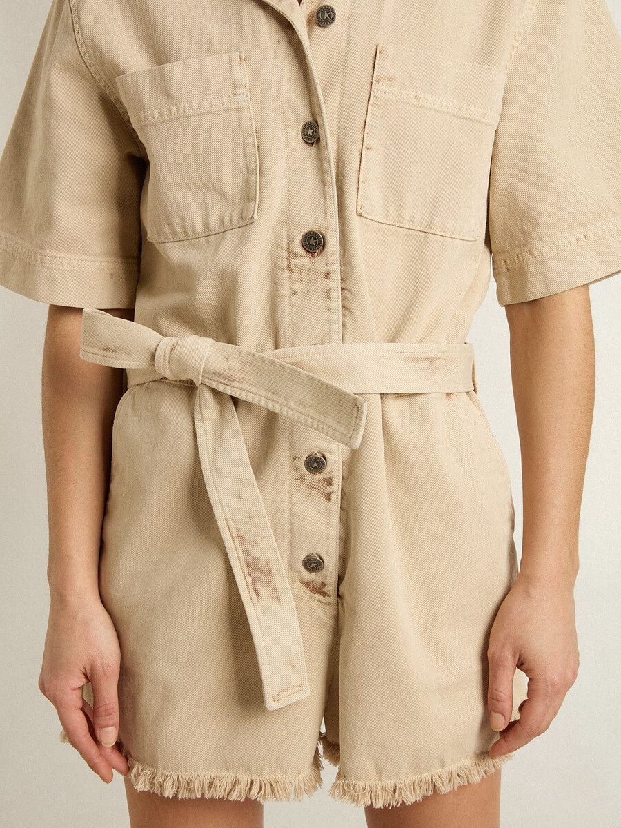 damesjumpsuit van beige denim met riem en gerafelde zoom.