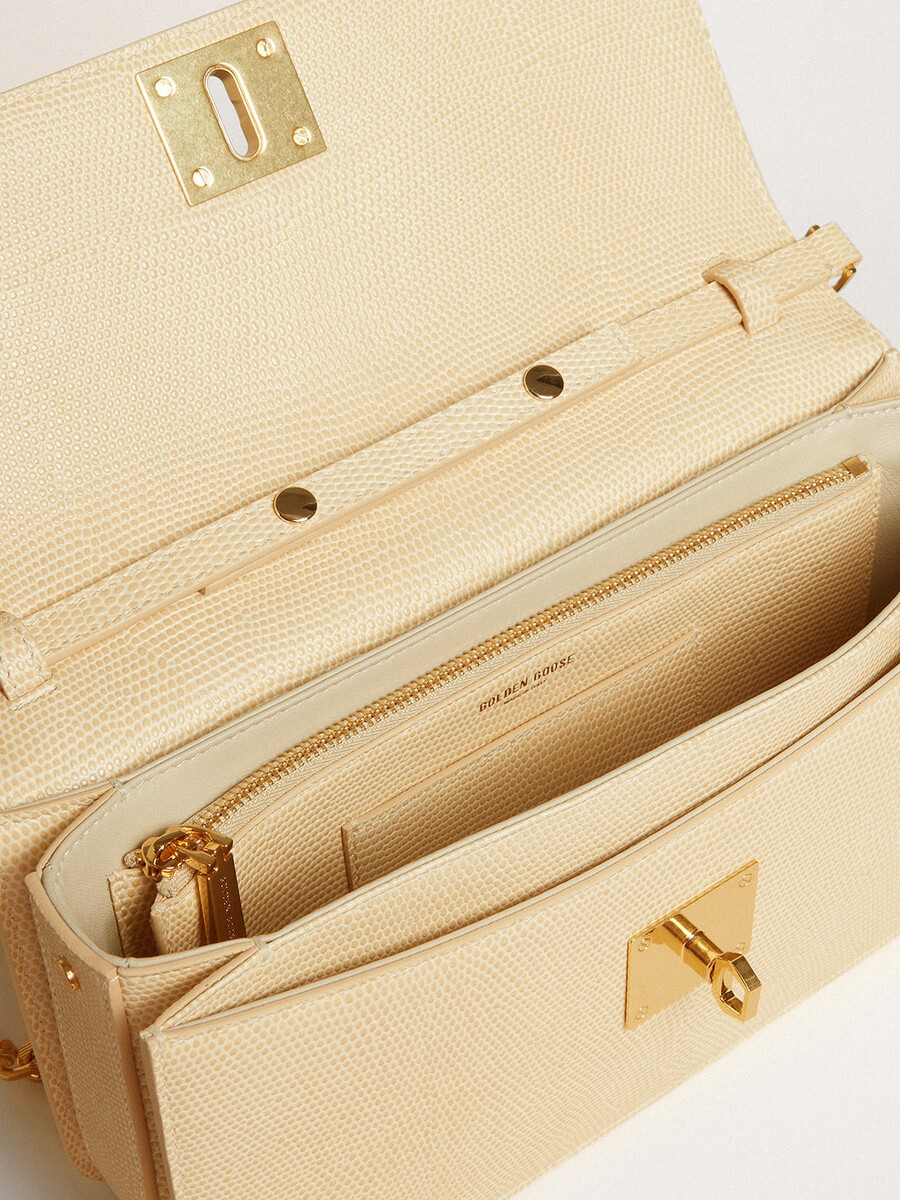 gioia-tas van vanillekleurig schapenleer met gouden details.