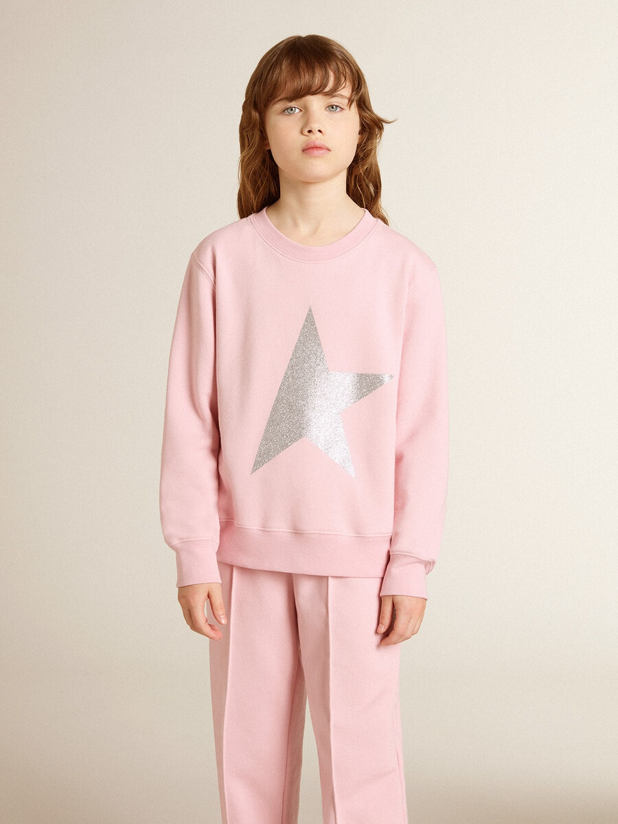 roze sweatshirt met een grote ster van zilveren glitter op de voorkant.