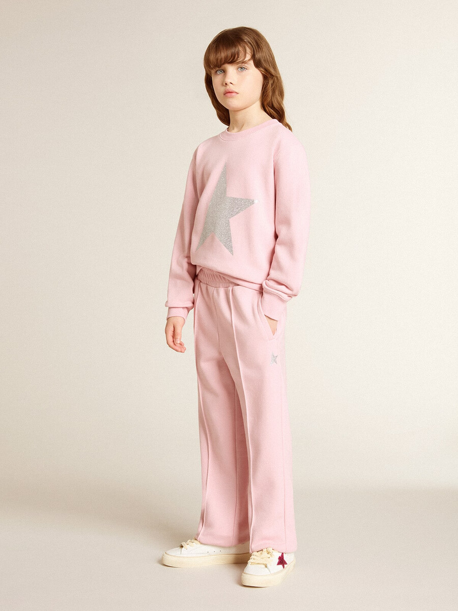 roze sweatshirt met een grote ster van zilveren glitter op de voorkant.