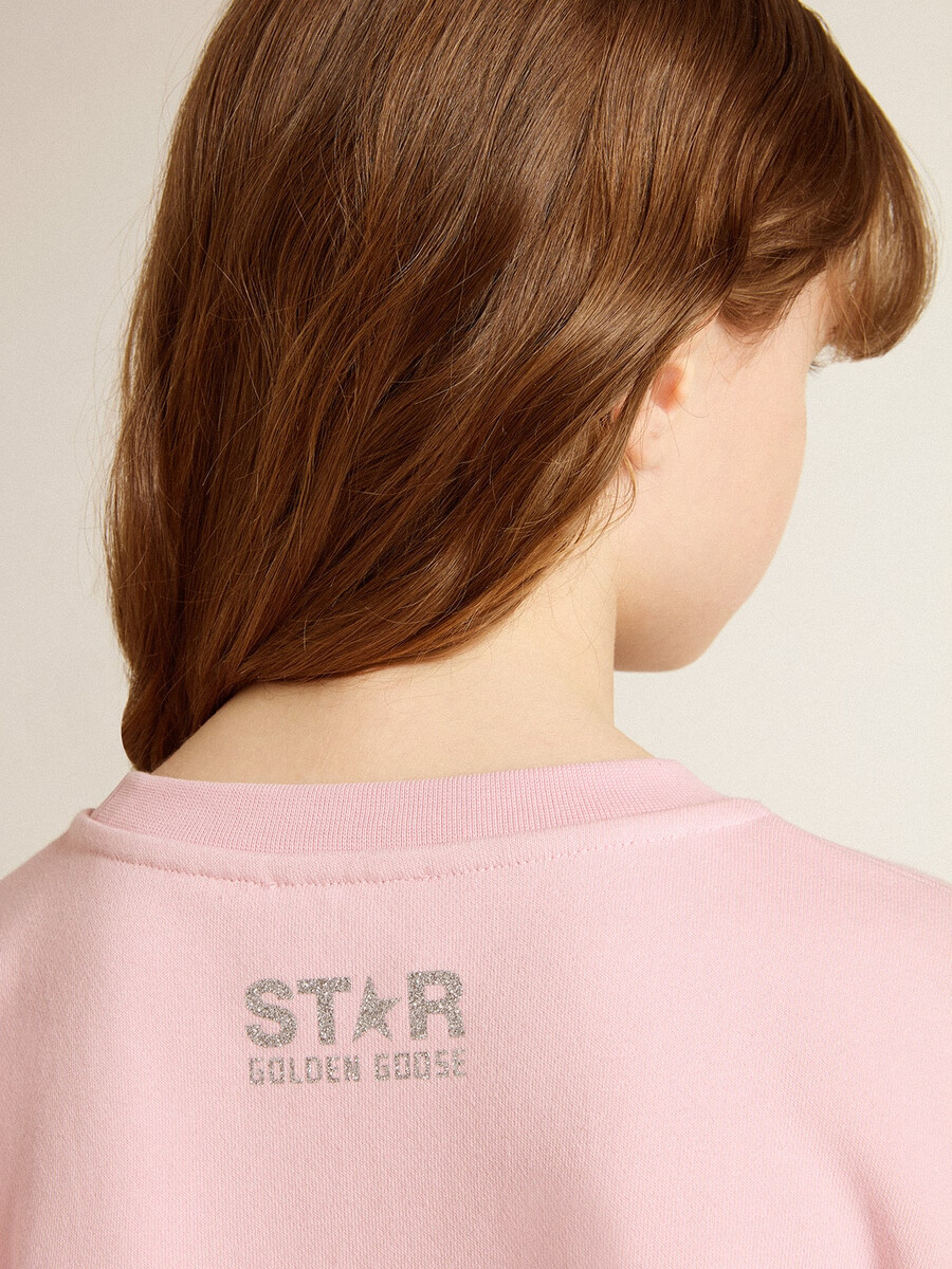 roze sweatshirt met een grote ster van zilveren glitter op de voorkant.