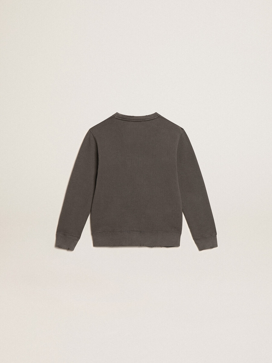 een verwassen grijze sweater met kristallen letters.