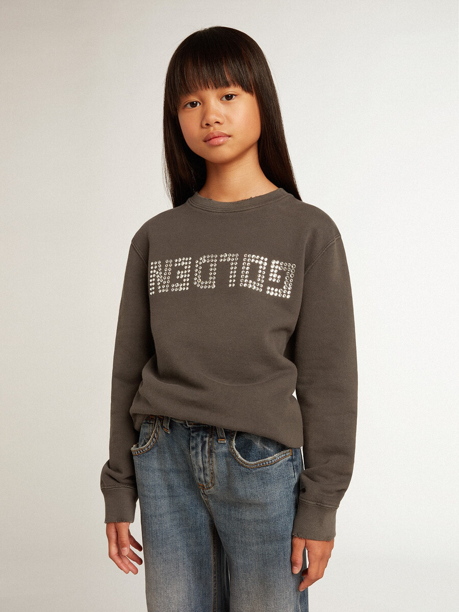 een verwassen grijze sweater met kristallen letters.