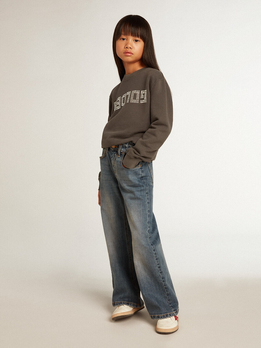 een verwassen grijze sweater met kristallen letters.