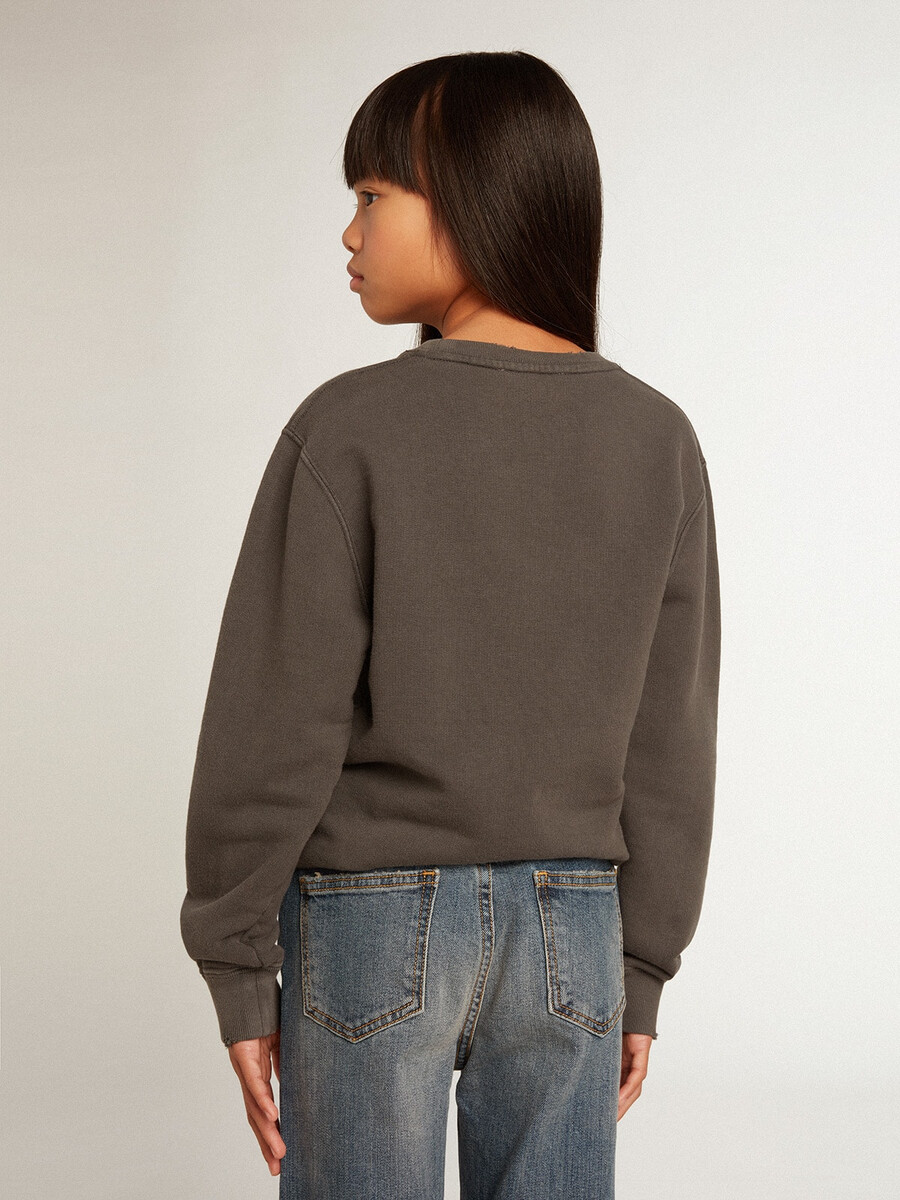een verwassen grijze sweater met kristallen letters.