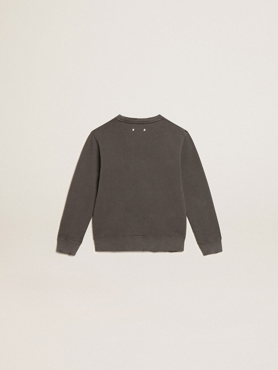 een verwassen grijze sweater met kristallen letters.