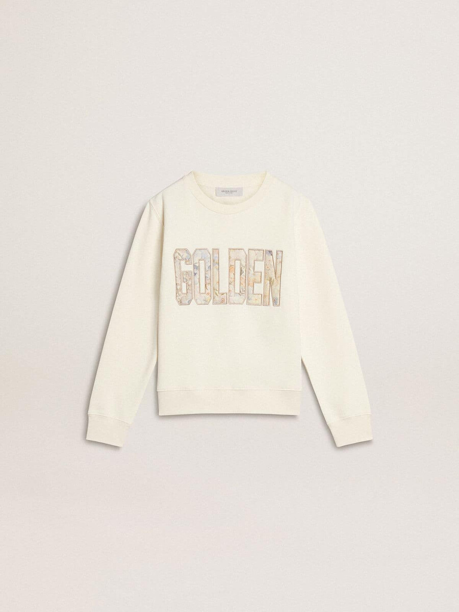 witte meisjestrui met veelkleurige gouden letters op de voorkant.