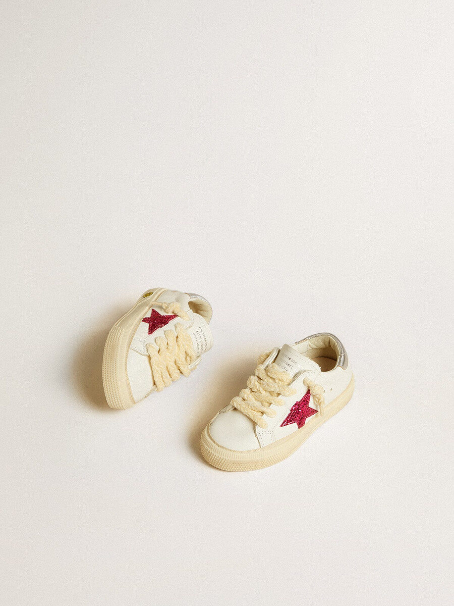 may junior met een fuchsia glitterster en een hielstuk van metallic leer.