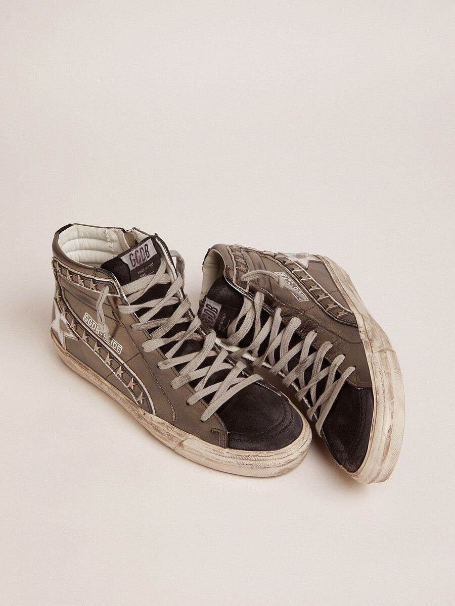 damesslippers met een bovenkant van zilverkleurig gelamineerd leer en studs.