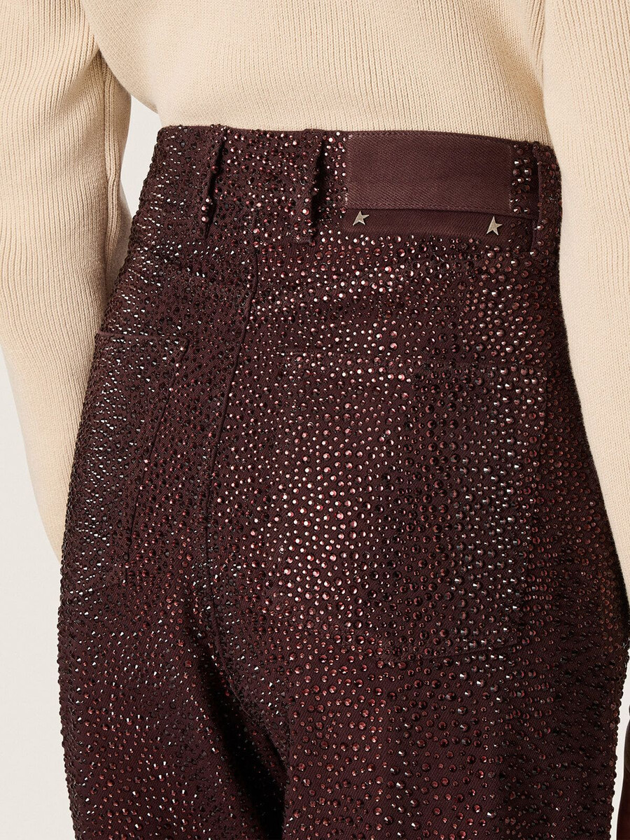 damesjeans van bordeauxrood denim met kristallen in kleurverloop.