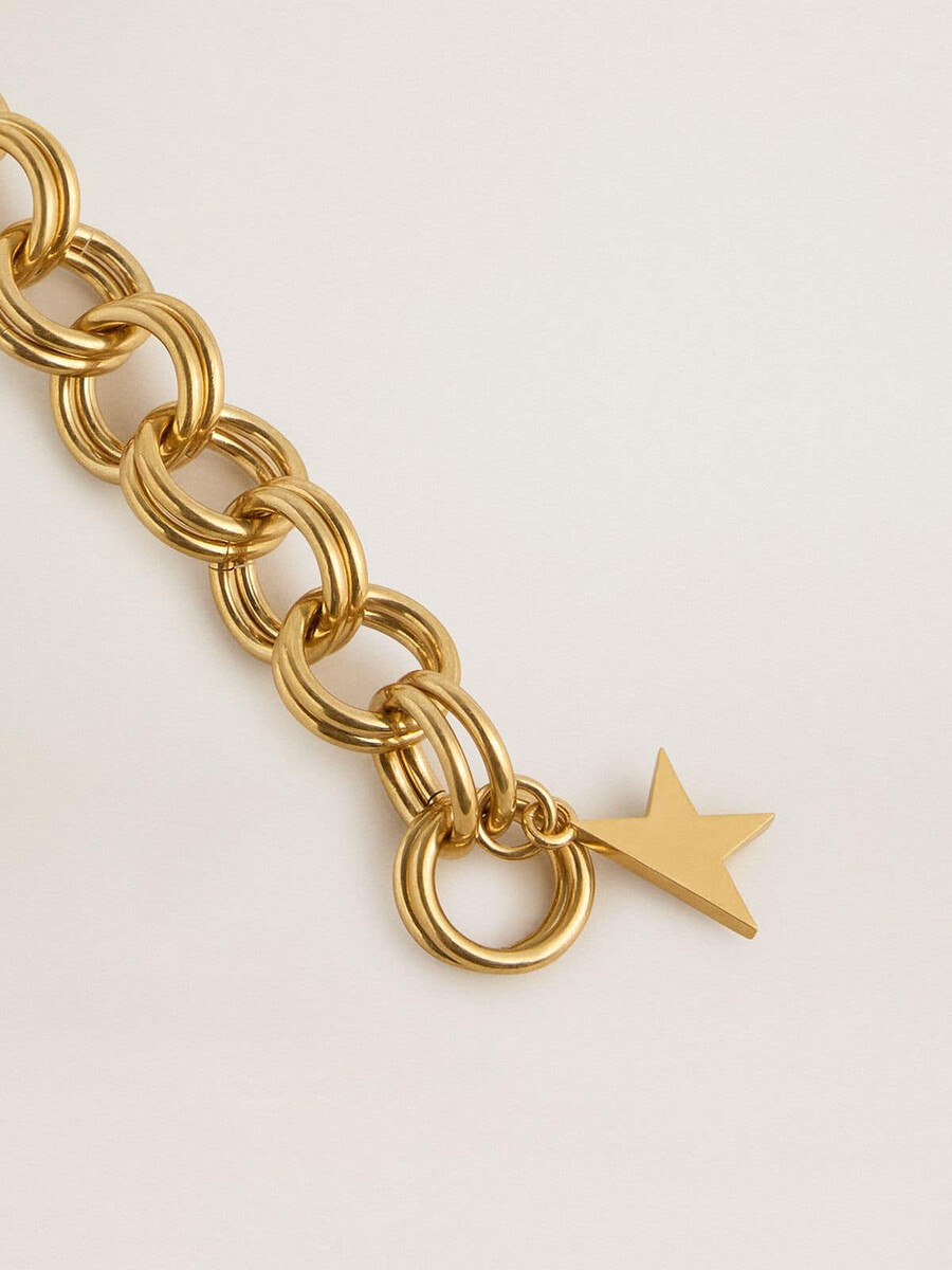 antieke goudkleurige armband met gevlochten schakels en een stervormige sluiting.