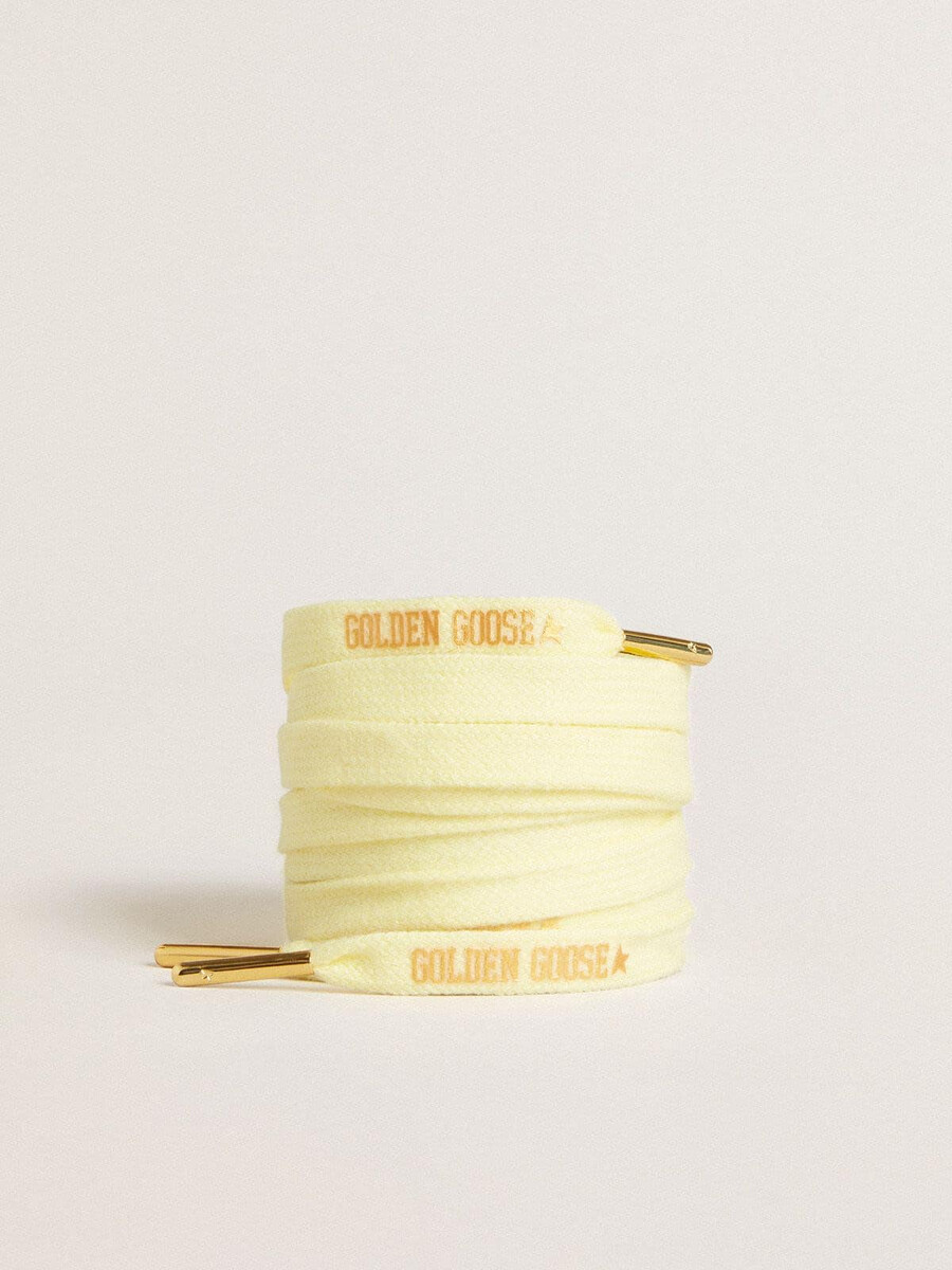 gele katoenen veters met een contrasterend goudkleurig logo.