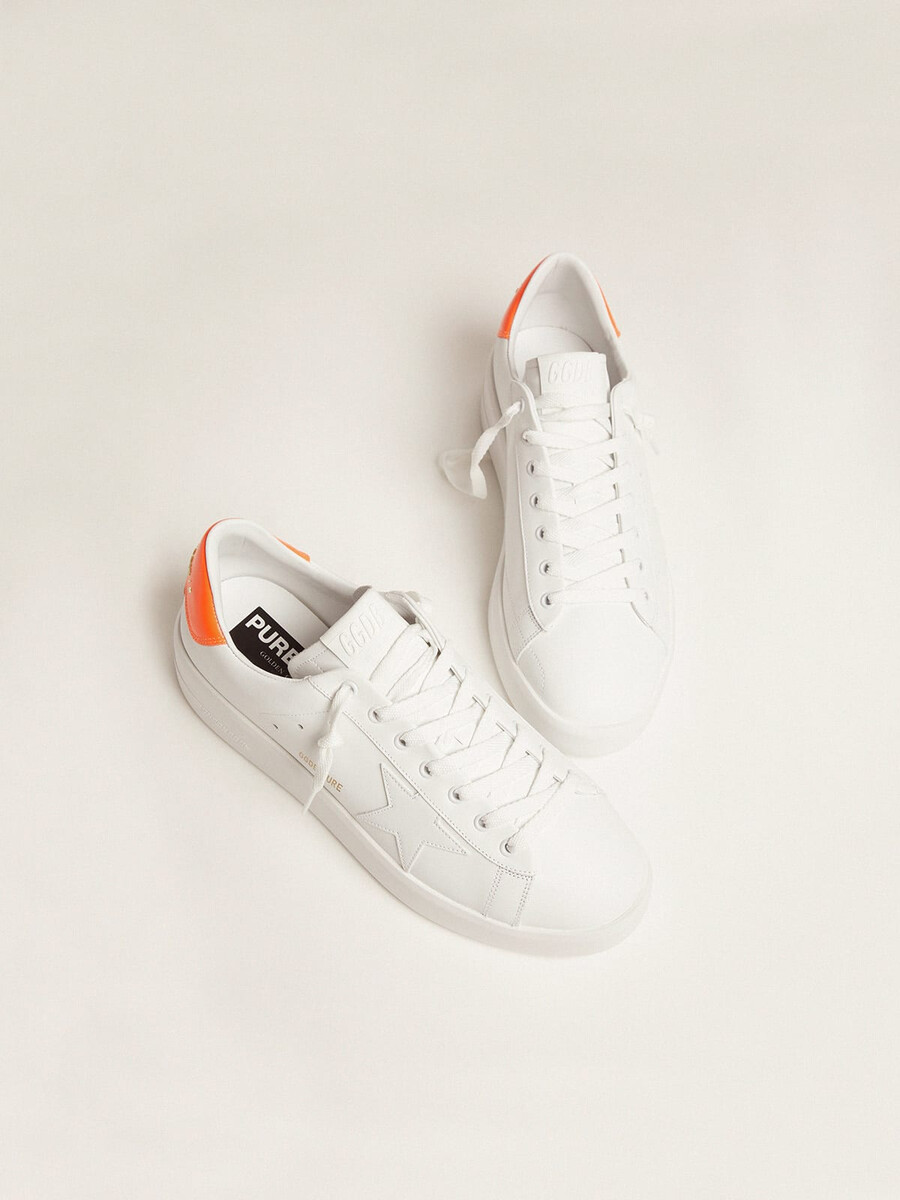 witte purestar sneakers met een fluorescerend oranje hielstuk.