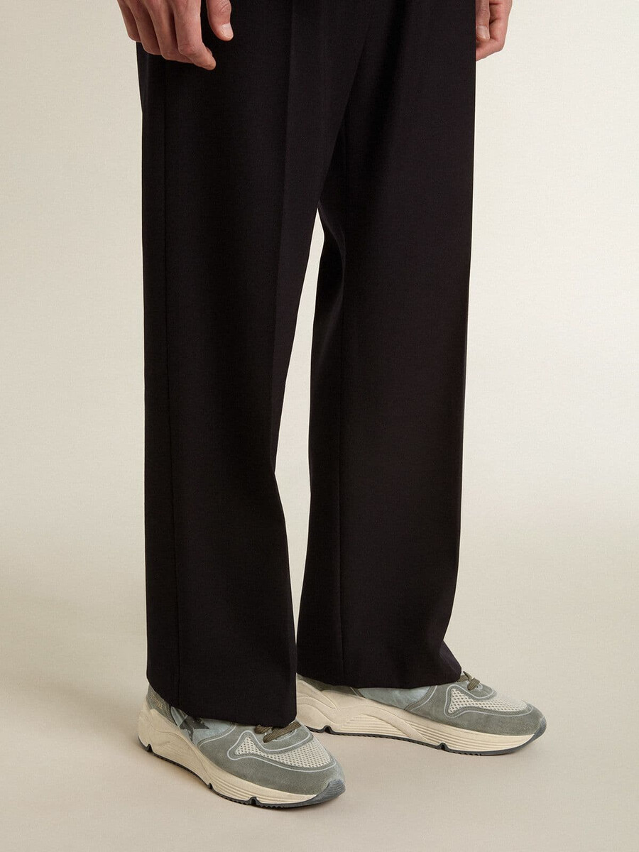 hardloopschoen voor heren met lichtblauwe nylon zool zwarte ster en groene leren hielband.