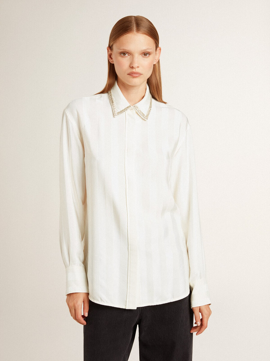 damesblouse met een verticaal streepmotief en kristallen borduursels.