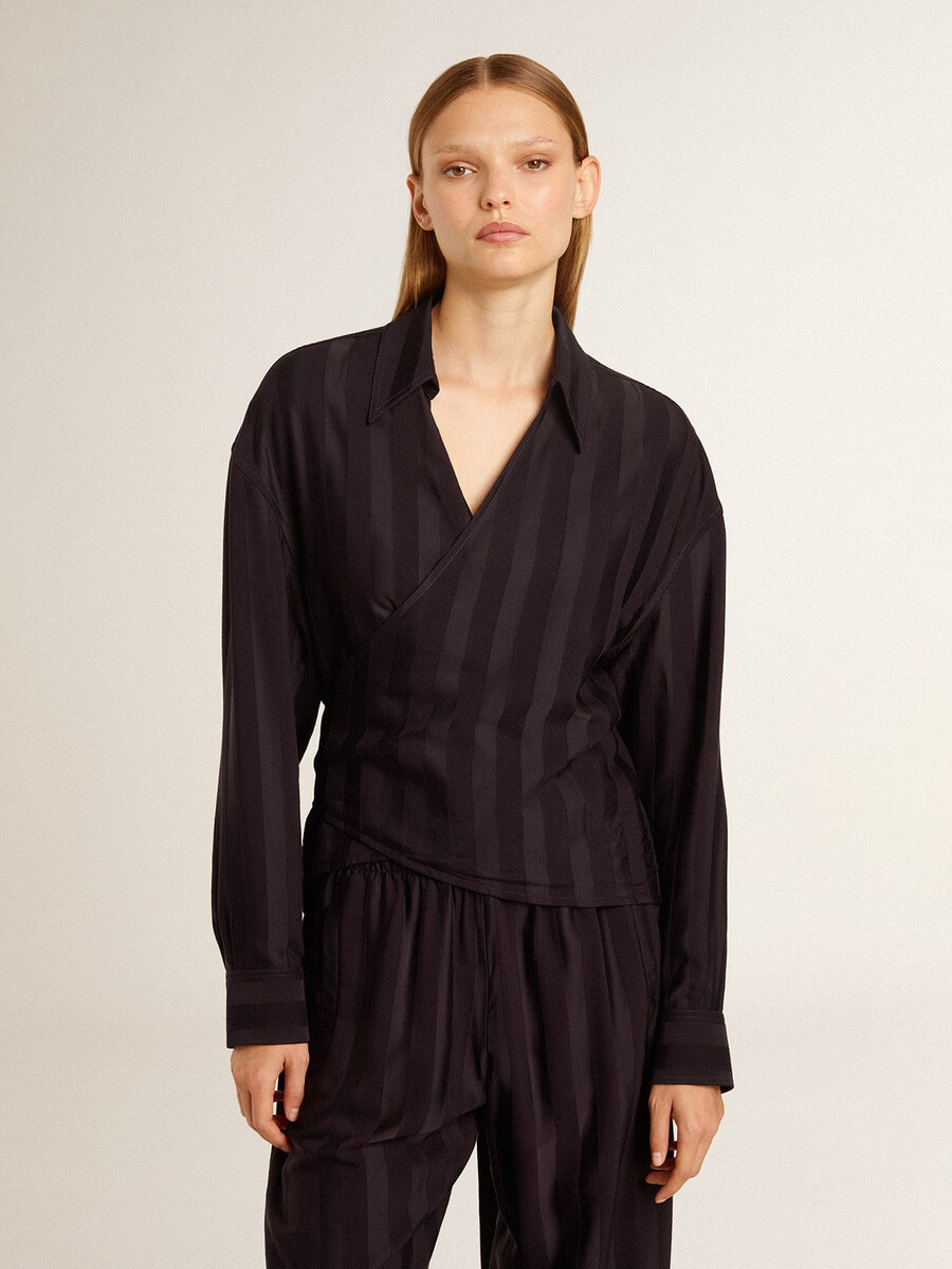 damesblouse in zwart met verticale strepen en knoopsluiting aan de zijkant.