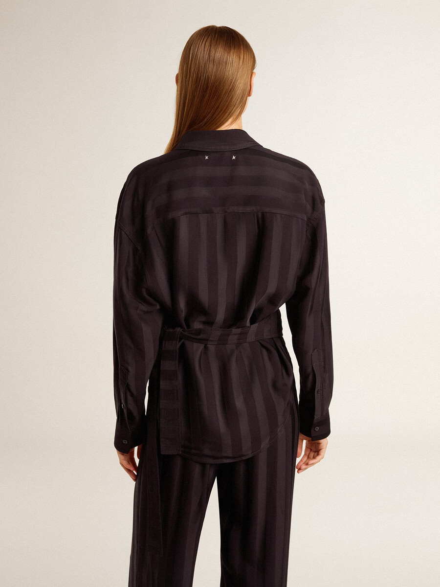 damesblouse in zwart met verticale strepen en knoopsluiting aan de zijkant.