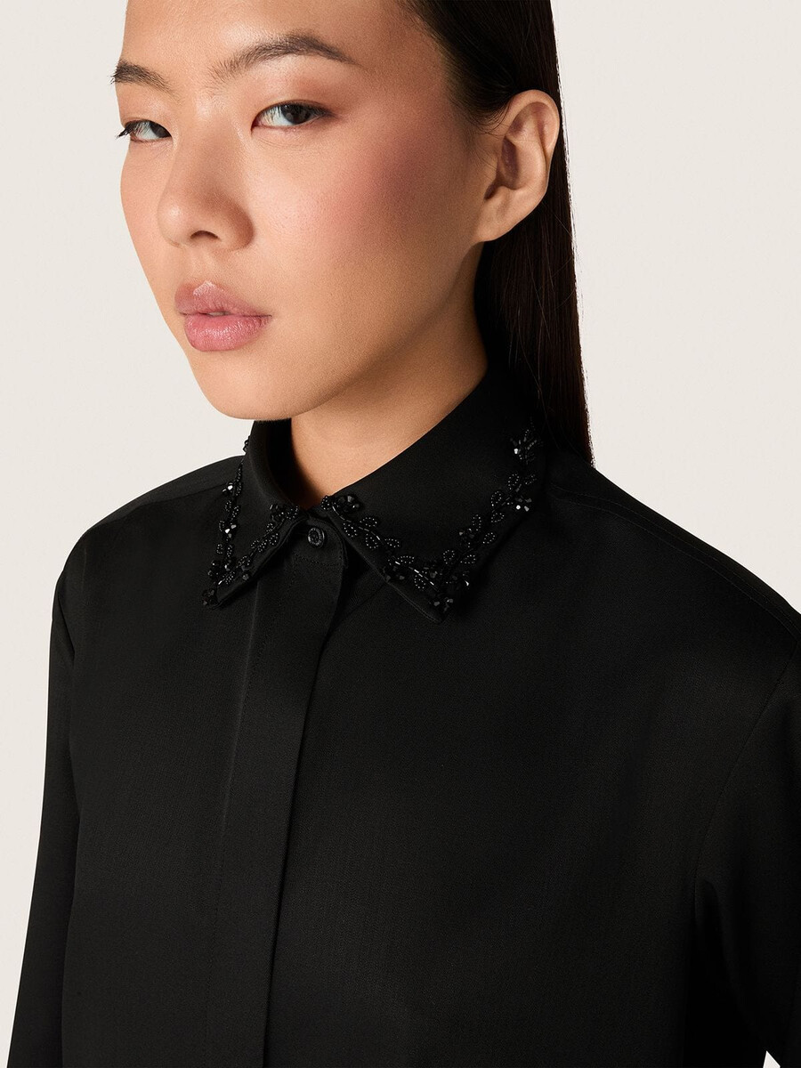 damesblouse van zwarte wollen keperstof met bloemenborduurwerk van glaskralen.