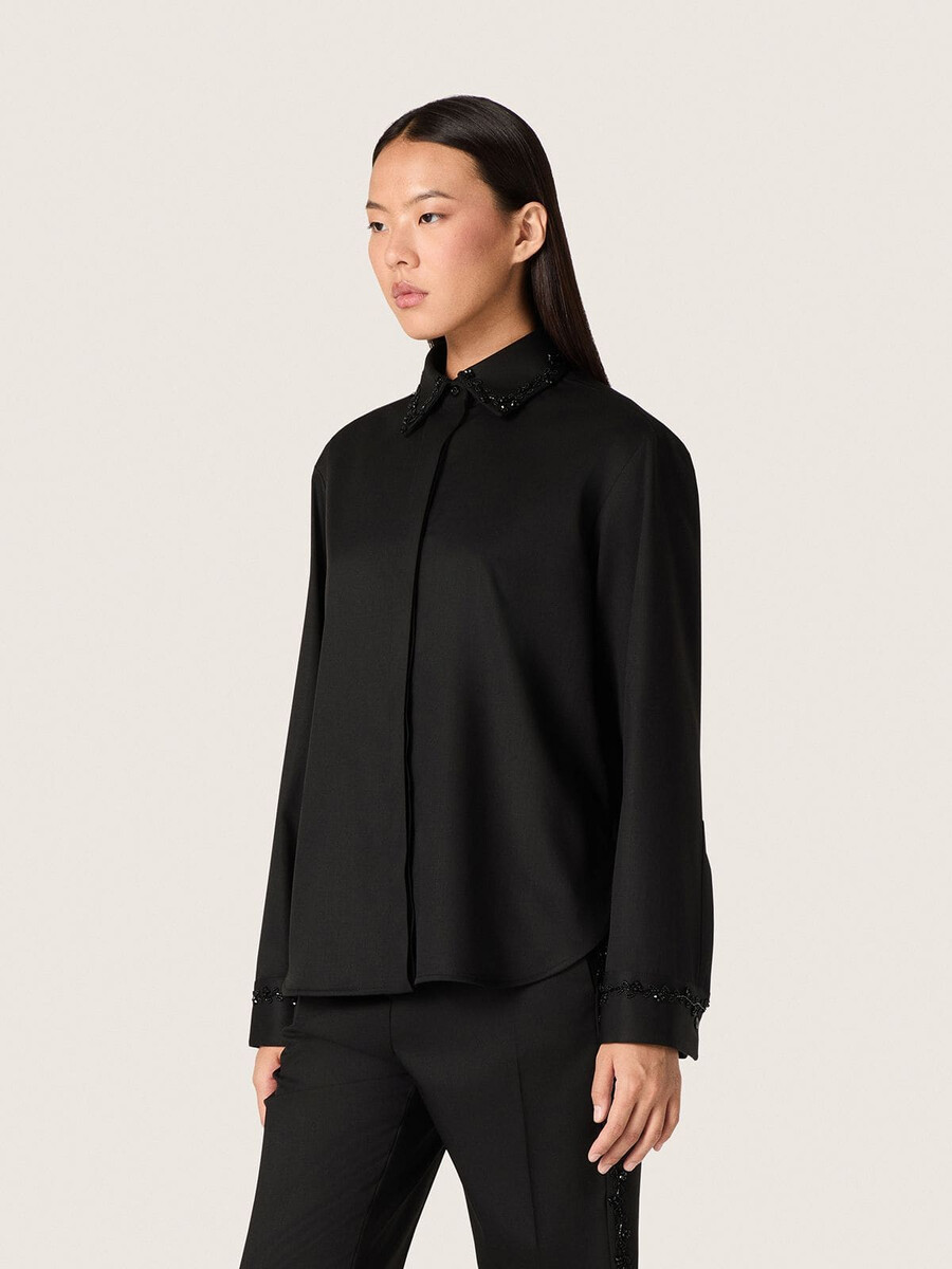 damesblouse van zwarte wollen keperstof met bloemenborduurwerk van glaskralen.