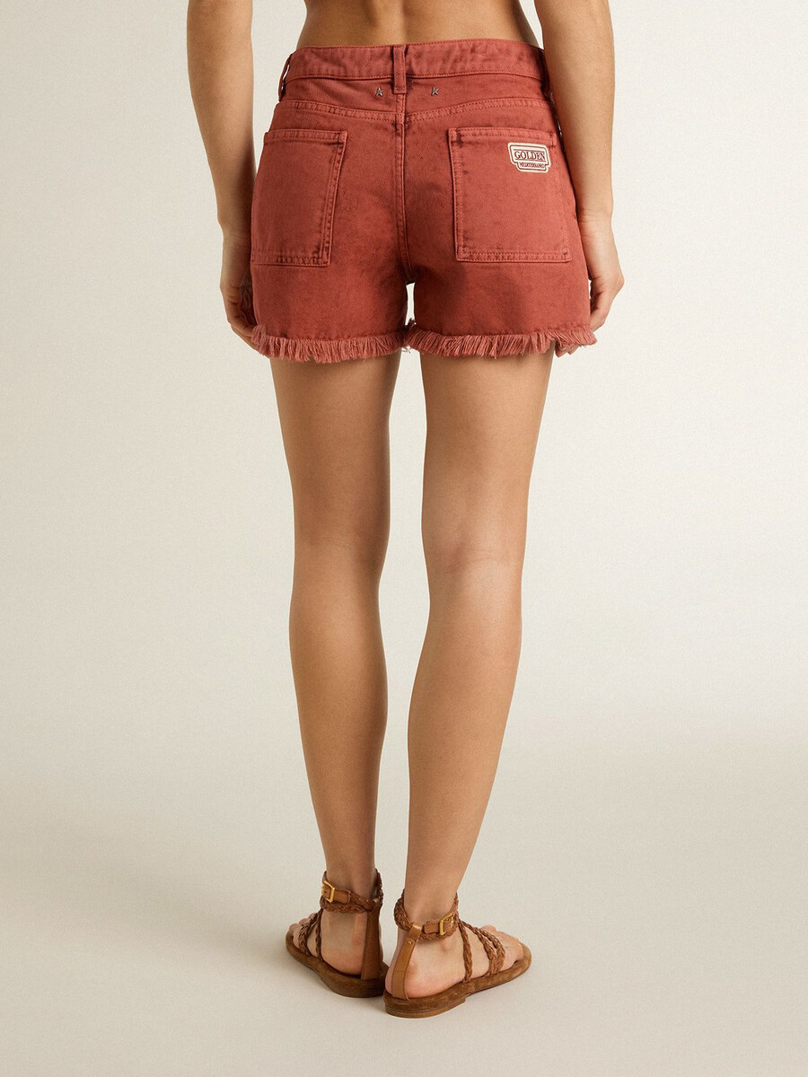 damesshorts van baksteenrood denim met golden mediterraneo-borduurwerk.