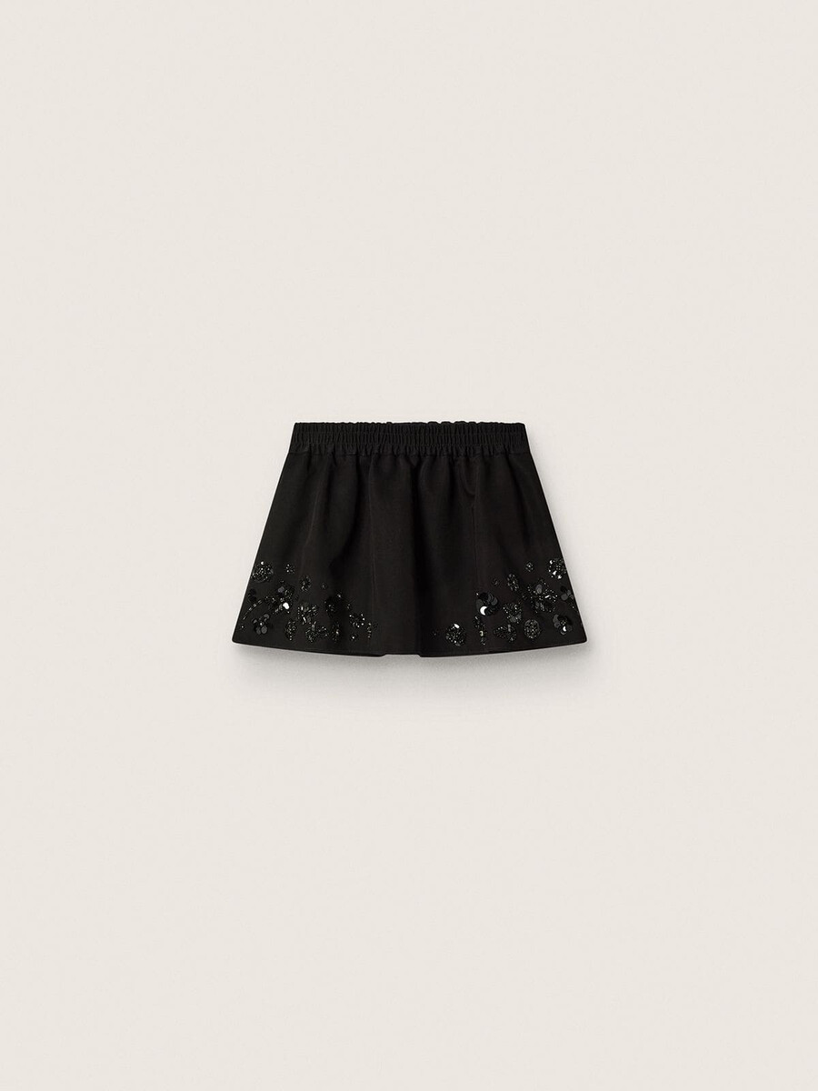 damesminirok van zwarte katoenen twill met geborduurde bloemen en pailletten.