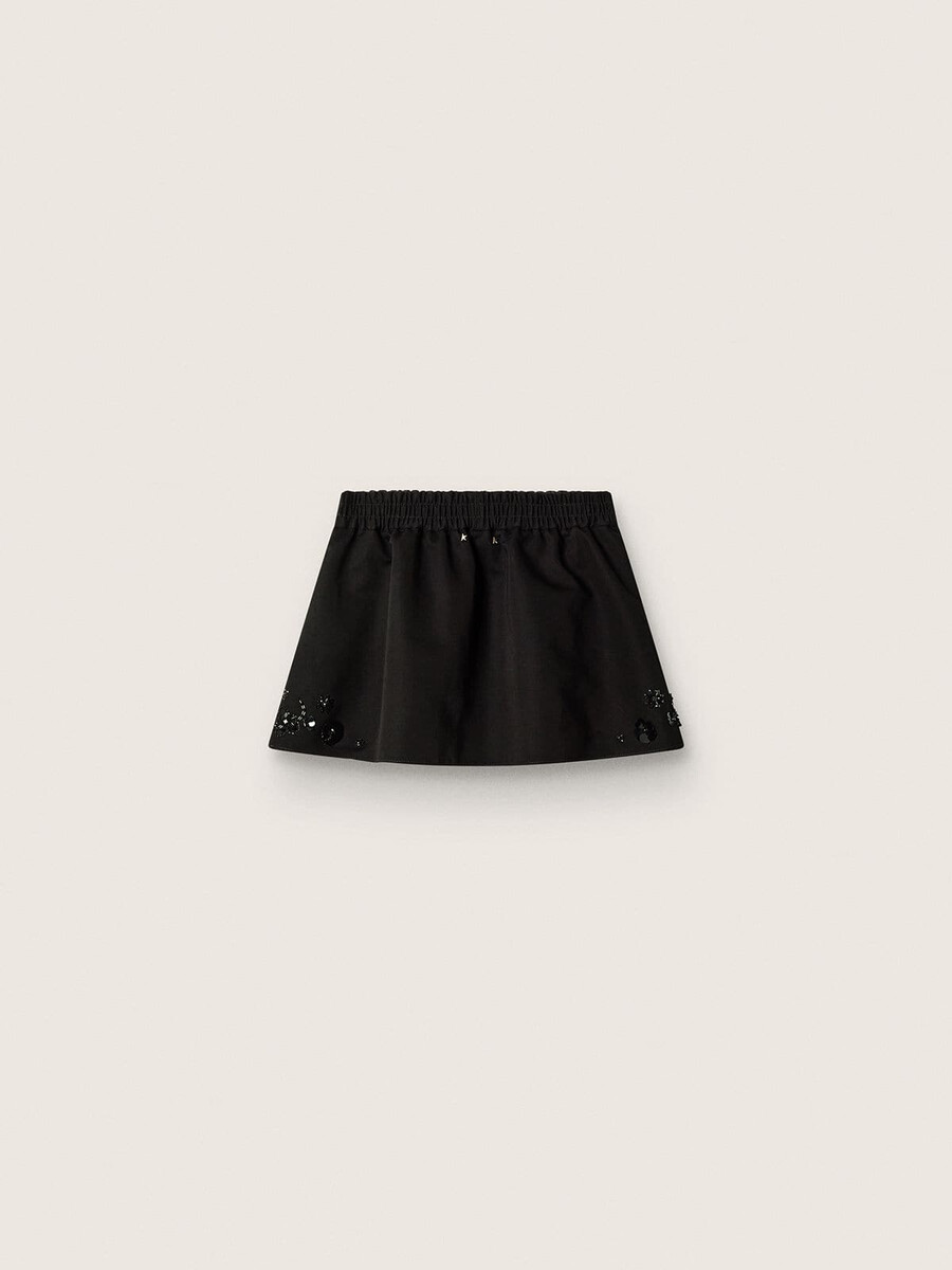 damesminirok van zwarte katoenen twill met geborduurde bloemen en pailletten.