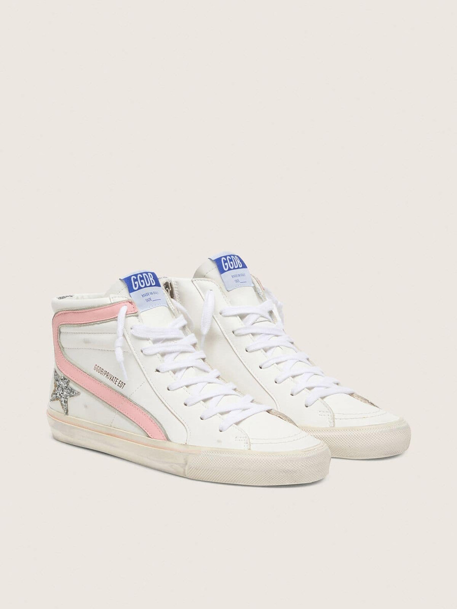 damesslippers van wit leer met zilveren glitterster en roze leren accenten.