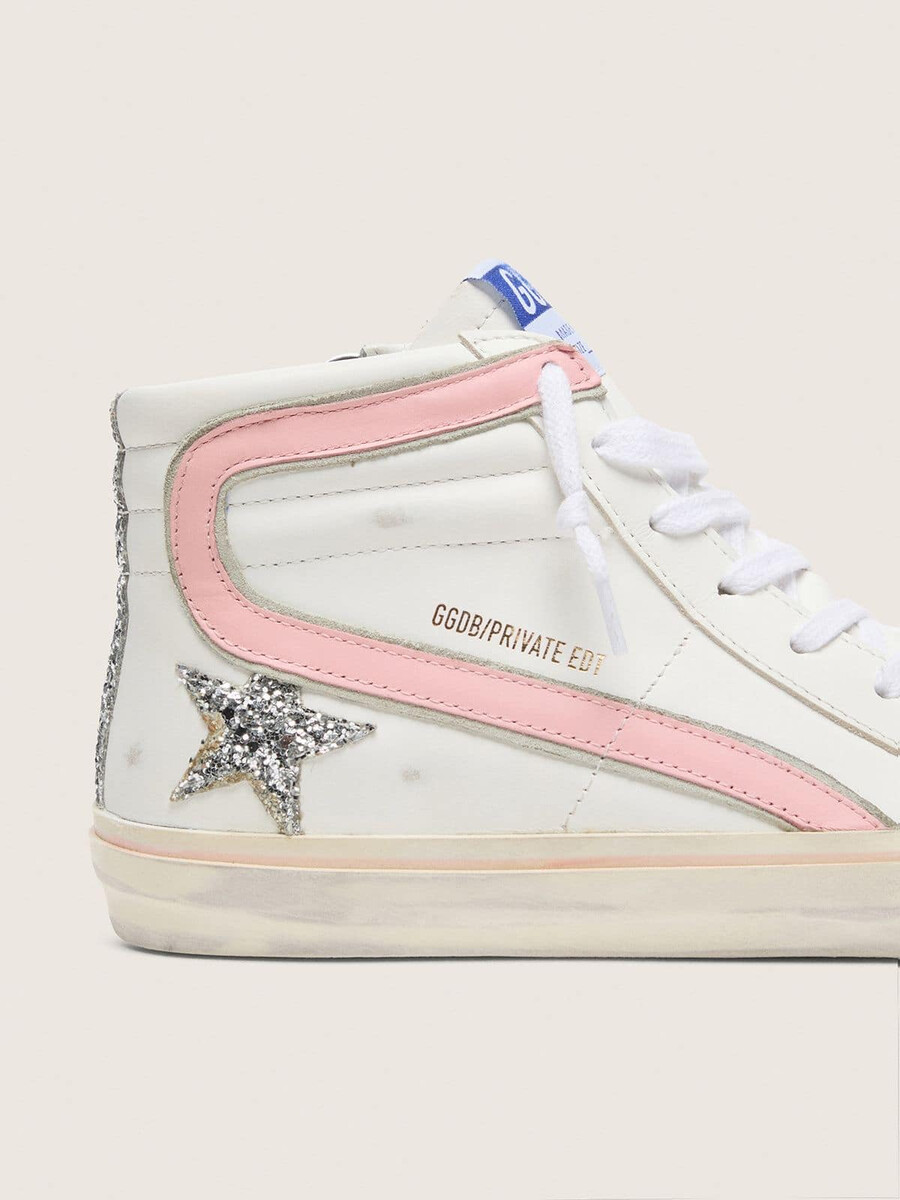 damesslippers van wit leer met zilveren glitterster en roze leren accenten.