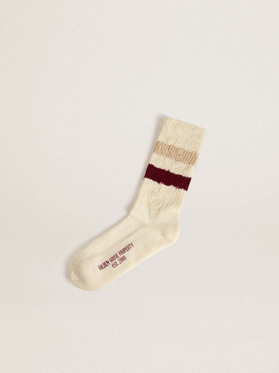 versleten witte sokken met een verweerde look en beige en bordeauxrode strepen.