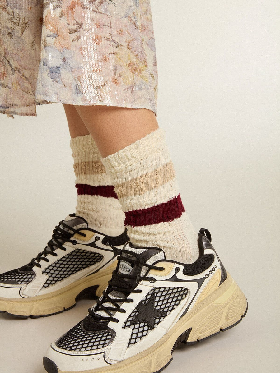 versleten witte sokken met een verweerde look en beige en bordeauxrode strepen.