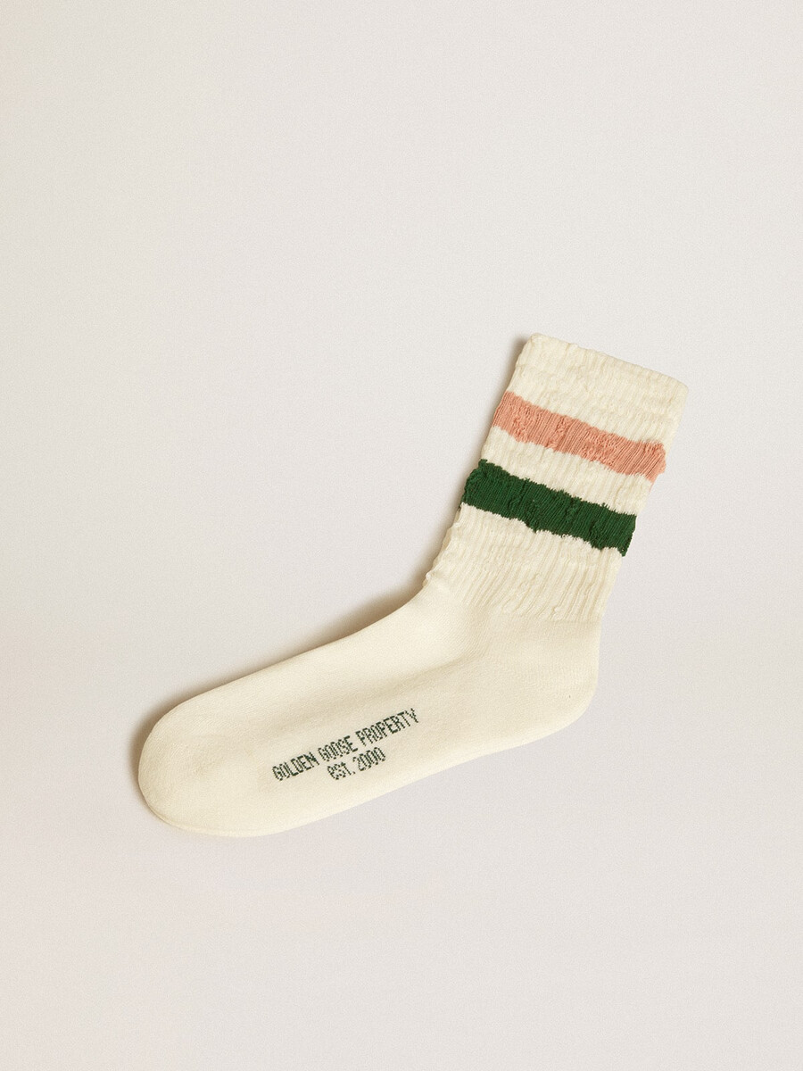 versleten witte sokken met een verweerde look en roze en groene strepen.