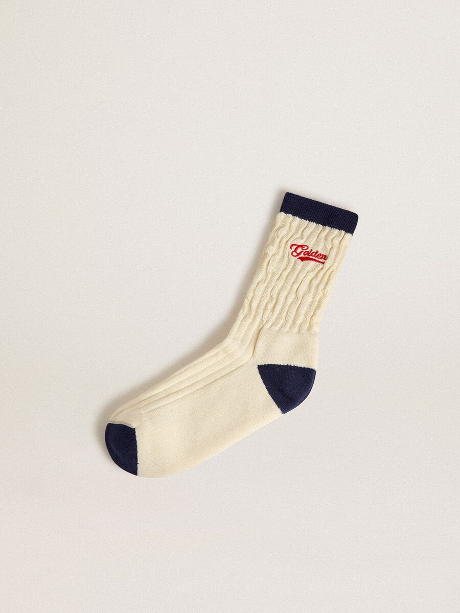 crèmekleurige ribbelsokken met marineblauwe details en rood logo.