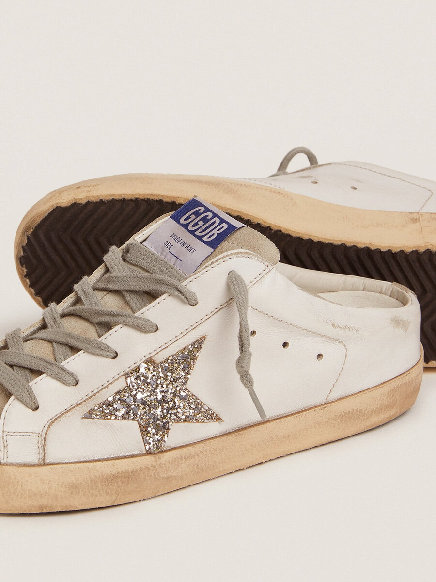 super-star sabot met een platina glitterster en een suède tong.