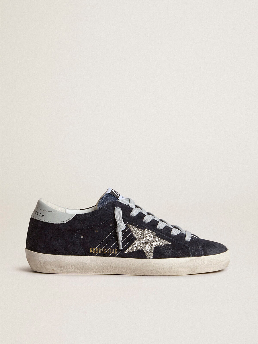 dames super-star in blauw suède met zilveren glitterster en leren hielstuk.