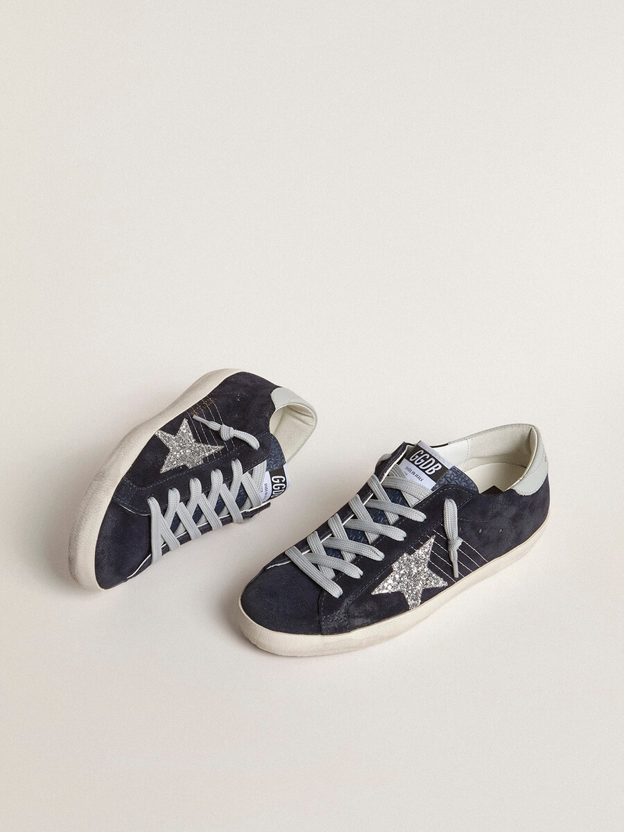 dames super-star in blauw suède met zilveren glitterster en leren hielstuk.