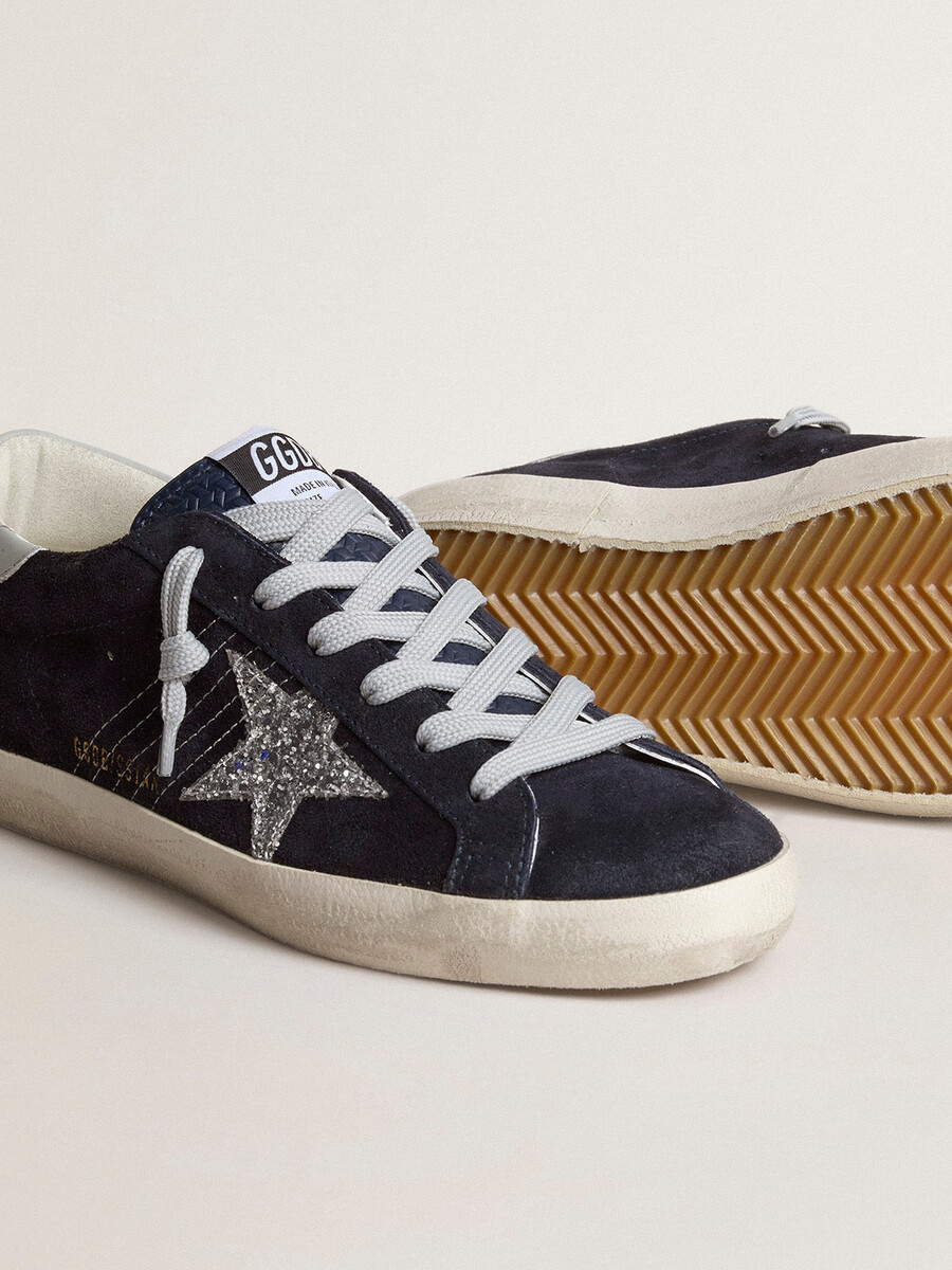 dames super-star in blauw suède met zilveren glitterster en leren hielstuk.